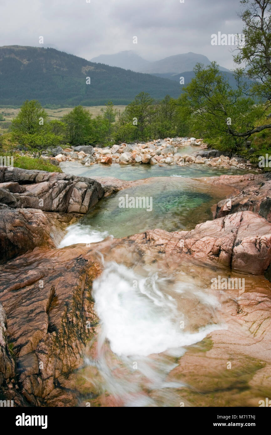 A fast flowing mountain stream, forming rock pools of cystal clear water. Glen Etive, Scottish Highlands, British Isles, May Stock Photo