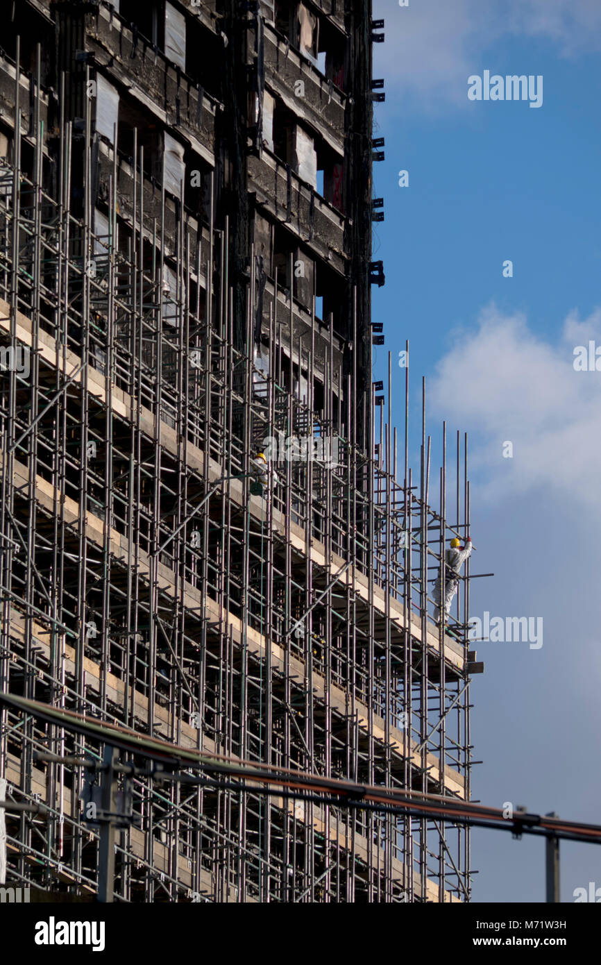 Construction workers building scaffolding before demolition of burnt ...
