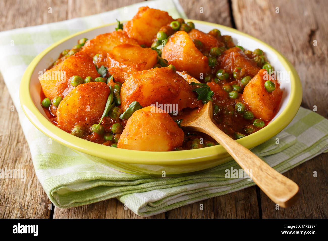 Vegetarian Indian Aloo Matar made from potatoes, green peas, herbs and spicy sauce closeup on a plate. horizontal Stock Photo
