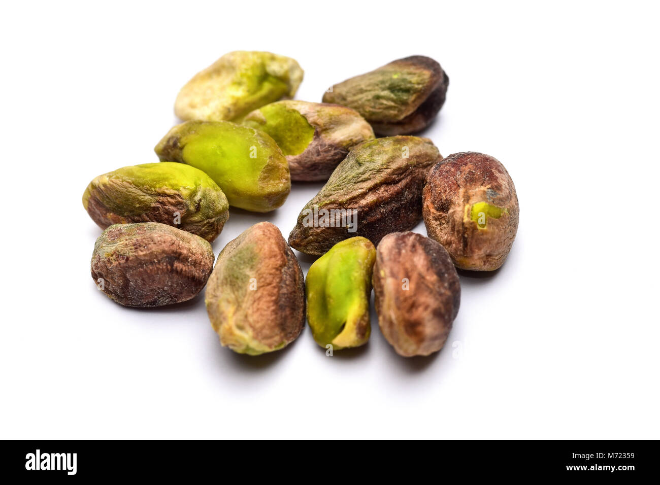 Pile of roasted pistachio nuts seeds (Pistacia vera) isolated on white