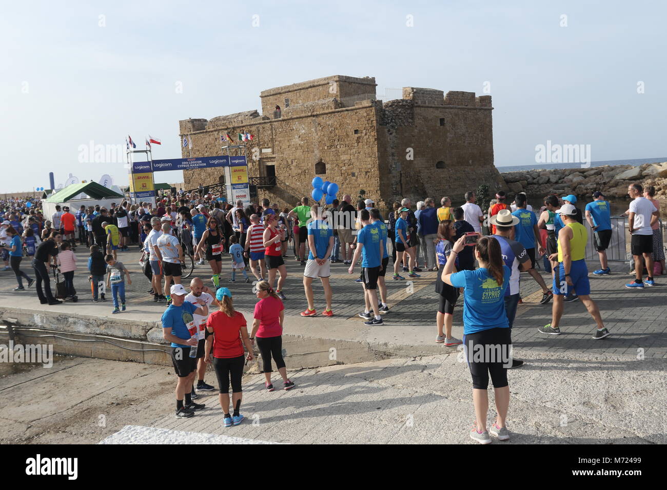 Competitor at the 20th Logicom Cyprus marathon, half marathon, 10KM, 5KM fun run taking pictures, Paphos harbour near Paphos fort, Cyprus, Europe Stock Photo