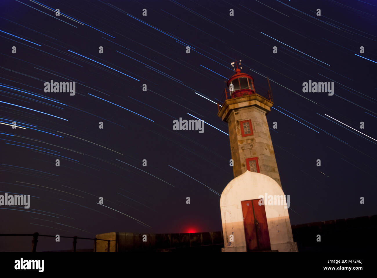 Lighthouse at night with startrails on the sky Stock Photo - Alamy