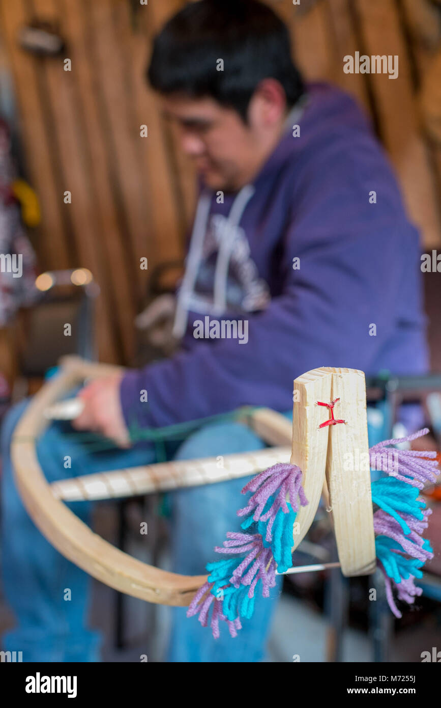 Young native man carving traditional snowshoes, Northern Quebec, Canada Stock Photo