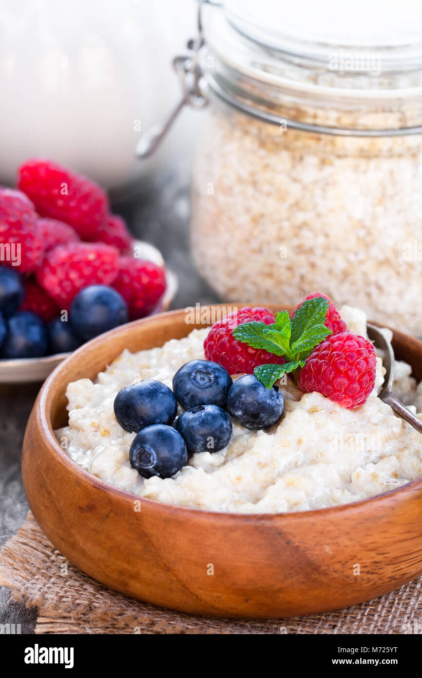 Porridge  in a wooden bowl with berries Stock Photo