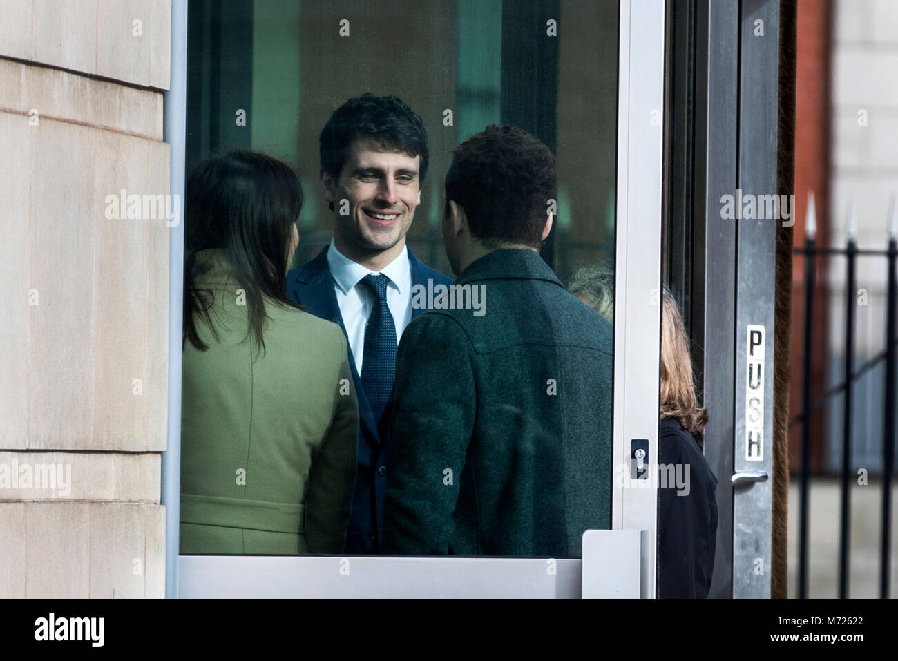 Blane McIlroy (centre) interacts with Ireland and Ulster rugby player Paddy Jackson (right) as they meet while queuing to enter Belfast Crown Court, where Mr McIlroy is on trial accused of one count of exposure, and Mr Jackson with his teammate Stuart Olding are on trial accused of raping a woman at a property in south Belfast in June 2016. Stock Photo
