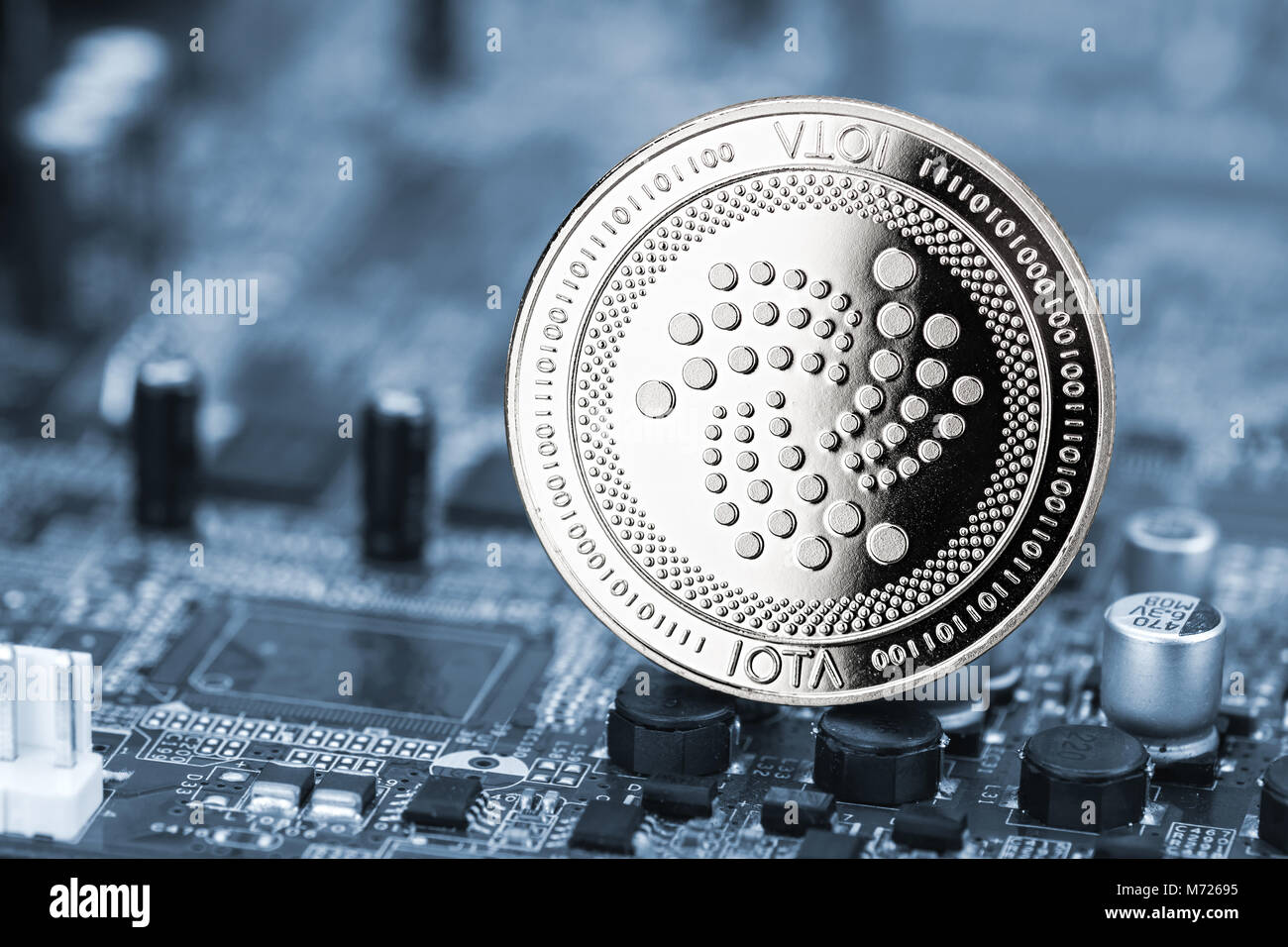 iota silver coin on blue motherboard chip digital mining computer hardware crypto currency