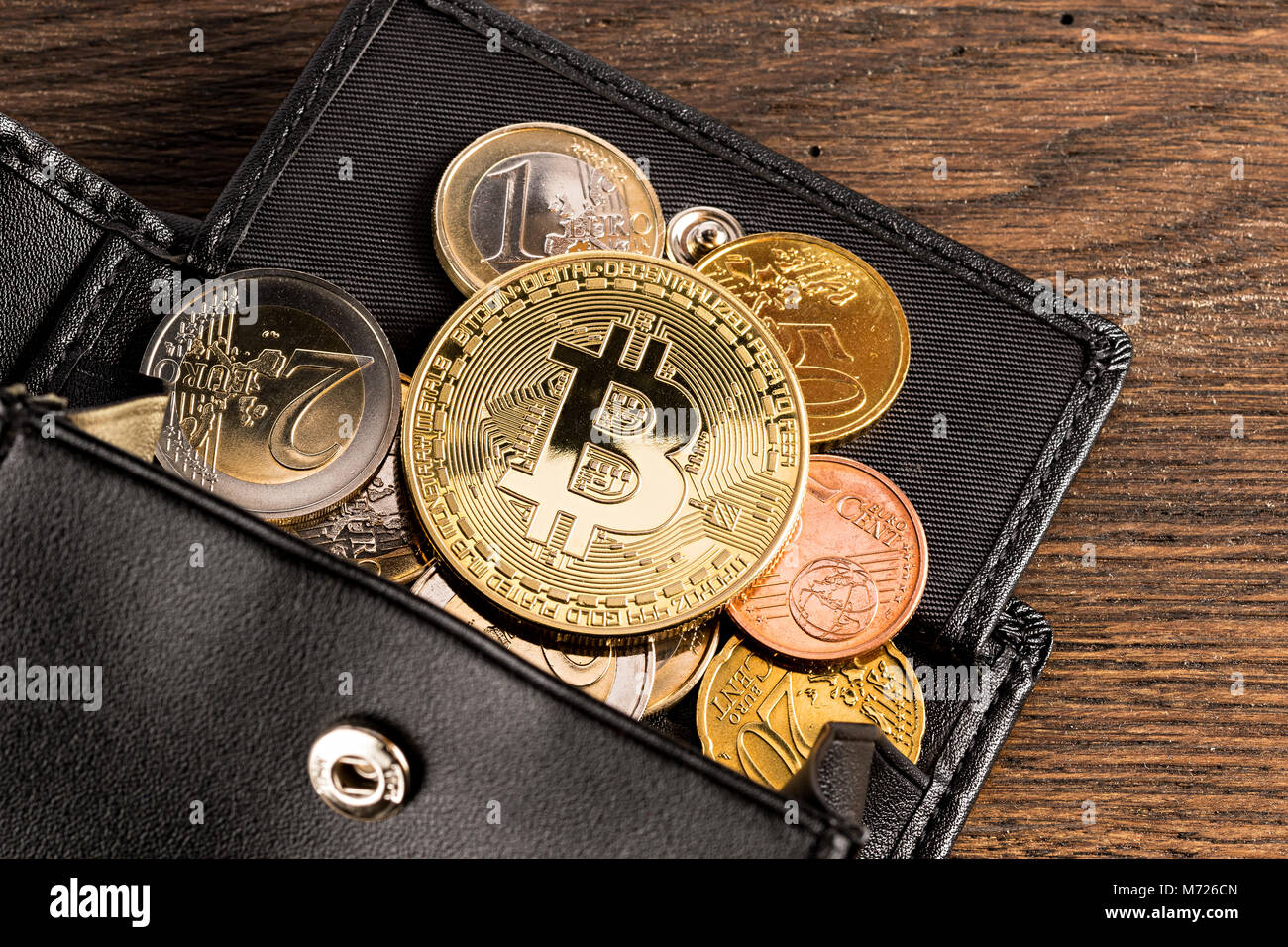 golden bitcoin crypto currency coin on euro coins in leather wallet on  wooden background Stock Photo - Alamy