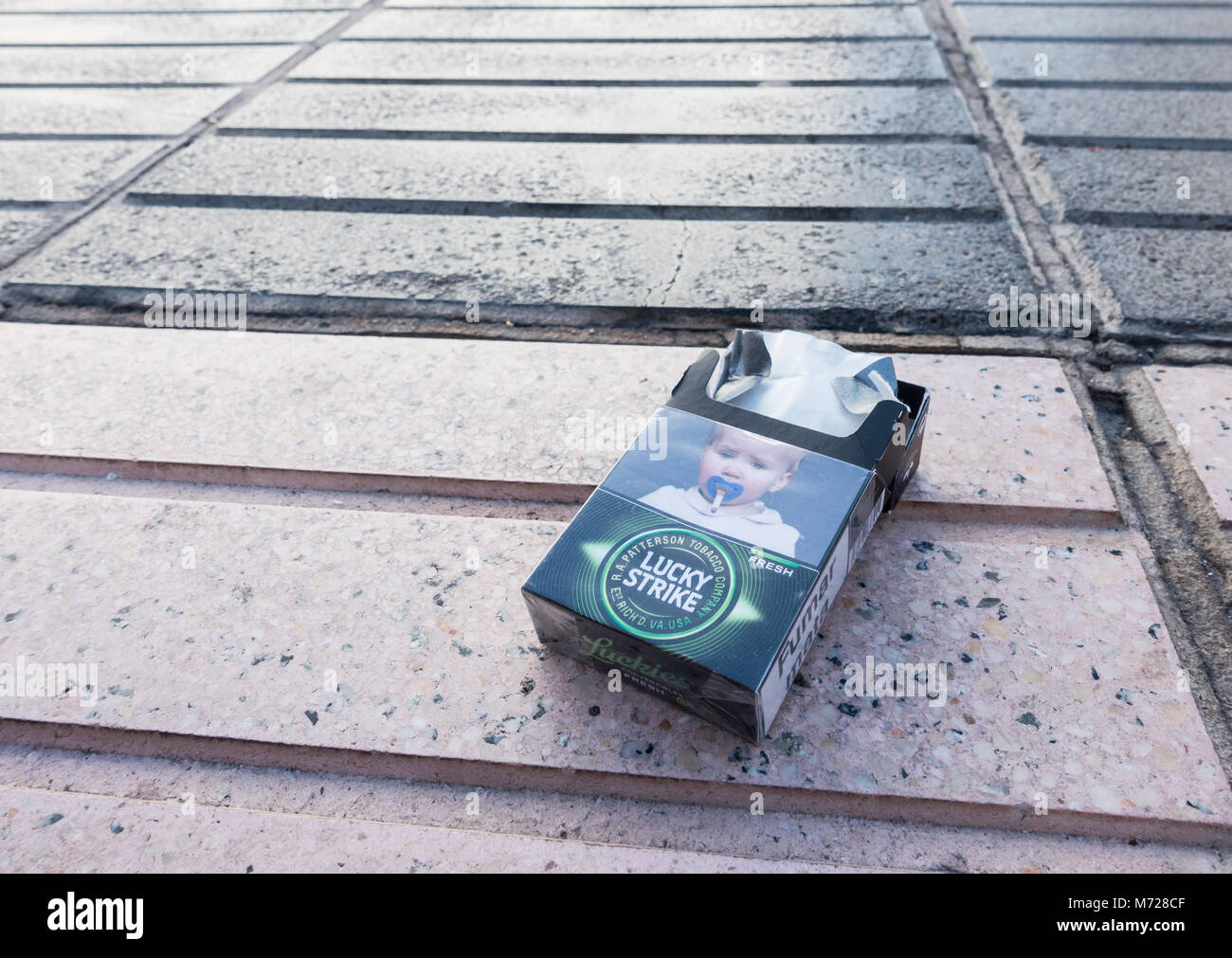 Health warning on discarded cigarette packet in Spain depicting a baby`s dummy with cigarette. Stock Photo