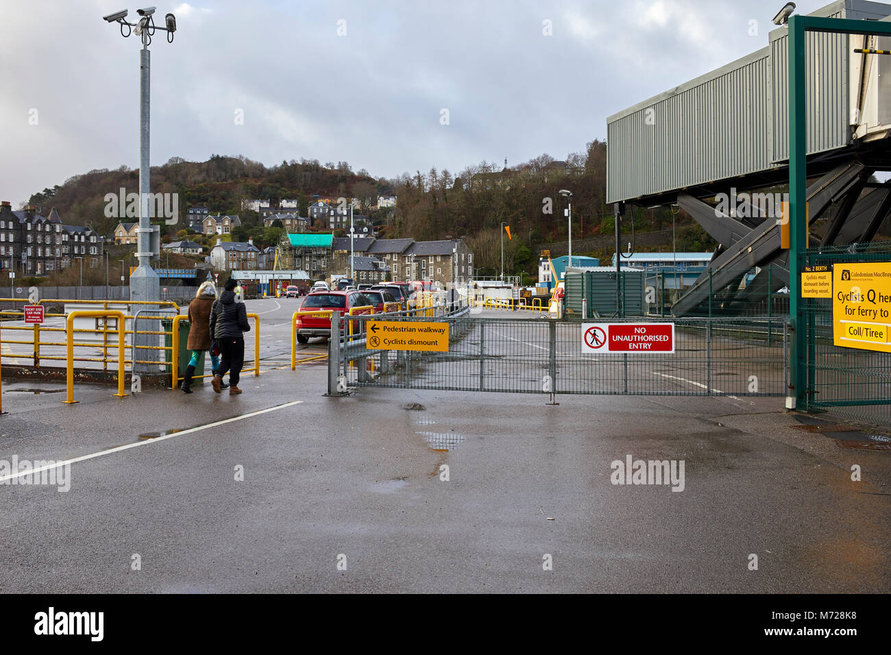 Passengers walking and waiting to board ferry to Mull at Oban Harbour Stock Photo