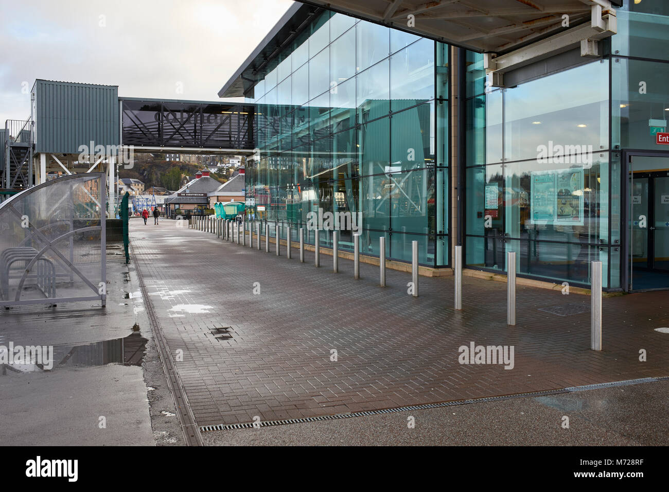 Glass fronted Caledonian MacBrayne ferry terminal at Oban Harbour with overhead pedestrian boarding walkway and bicycle park. Stock Photo