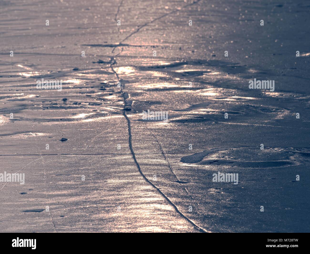 Shards of cracked ice jut out on the frozen lake. The light phenomenon occurs around a very specific time of year Stock Photo