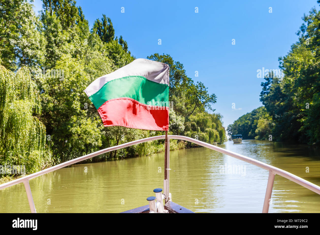 Boat With Flag For Trip On The River Kamchia River In Bulgaria Stock boat-with-flag-for-trip-on-the-river-kamchia-river-in-bulgaria-stock