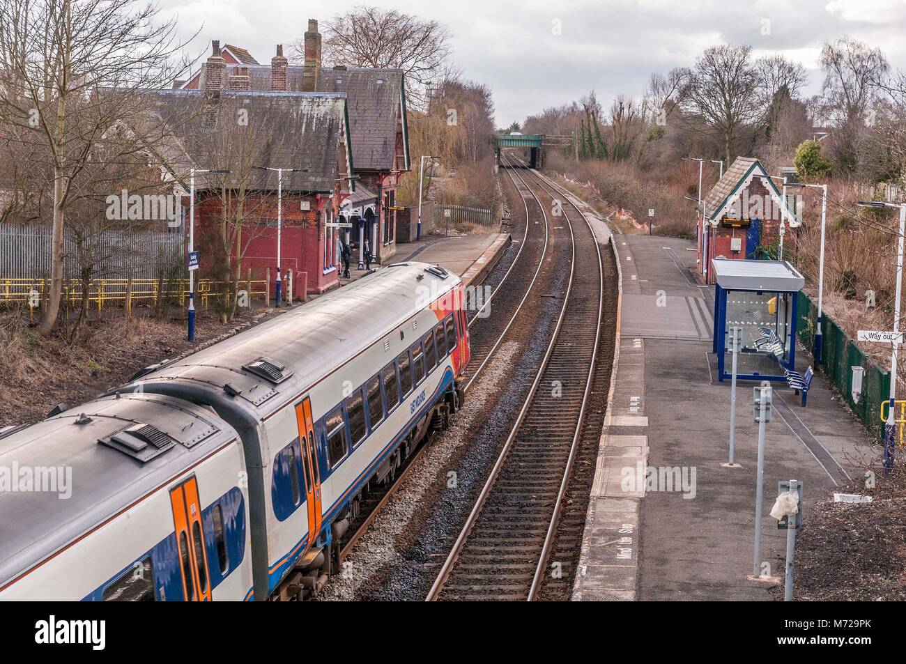 A Class 156 diesel multiple unit train passing through the rural station at Sankey in Cheshire. East Midlands Trains Stock Photo