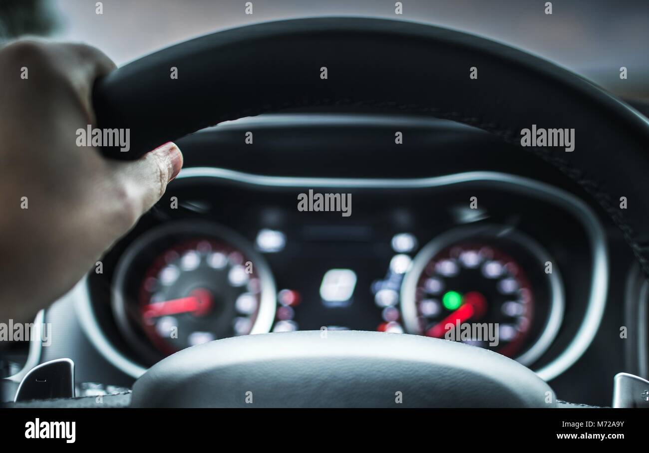 Hand on the Vehicle Steering Wheel. Car Road Trip Concept. Stock Photo