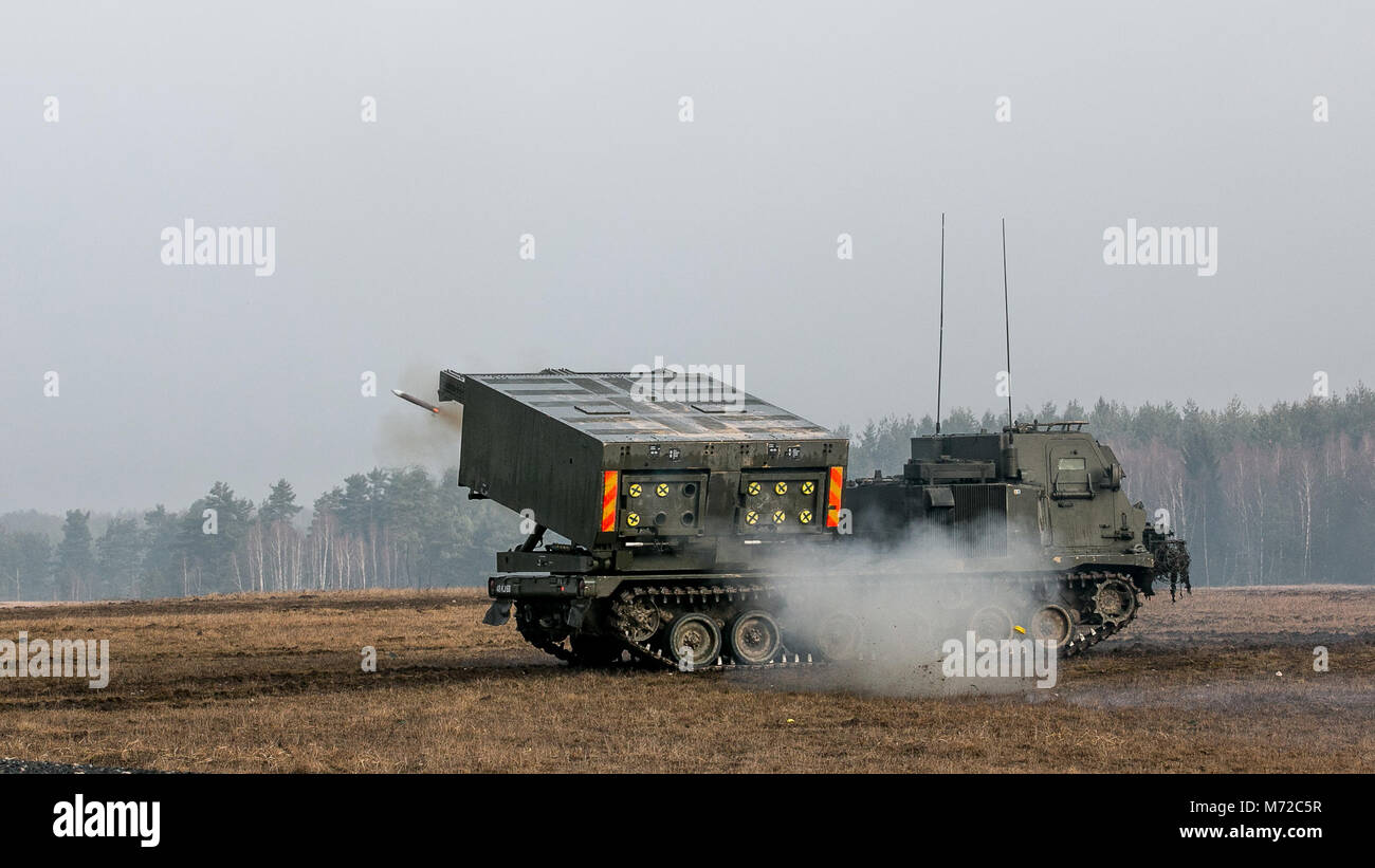 British soldiers from 176th Battery, 19th Regiment Royal Artillery, conduct live fire training using the multiple launch rocket system during Dynamic Front 18 in Grafenwoehr, Germany, March 7, 2018. Exercise Dynamic Front 18 includes approximately 3,700 participants from 26 nations training together from Feb. 23-March 10, 2018. Dynamic Front is an annual U.S. Army Europe (USAREUR) exercise focused on the interoperability of U.S. Army, joint service and allied nation artillery and fire support in a multinational environment, from theater-level headquarters identifying targets to gun crews pulli Stock Photo