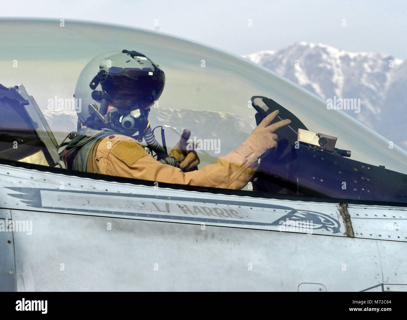 “Mach”, 77th Expeditionary Fighter Squadron F-16 Fighting Falcon fighter pilot, signals from his aircraft prior to taking off Feb. 28, 2018 at Bagram Airfield, Afghanistan. Reaching the 1000 hour mark as a fighter pilot represents a significant career accomplishment. Even more so for “Mach” because all of his combat hours were flown with the 77th EFS and no other pilot has ever done that. (U.S. Air Force photo/Staff Sgt. Divine Cox) Stock Photo