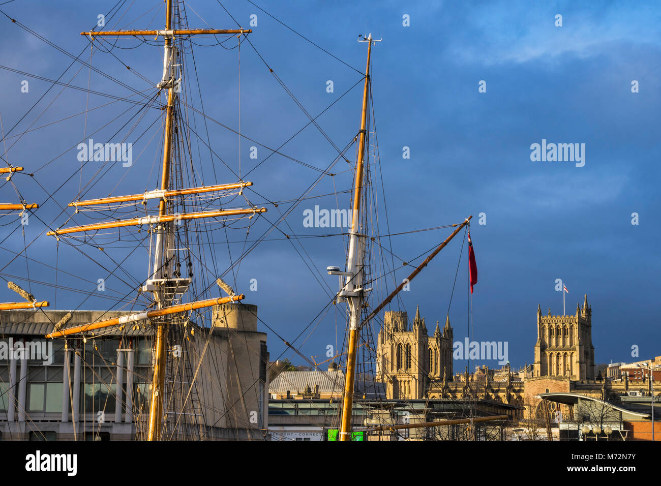 Bristol Cathedral - The Cathedral Church of the Holy and Undivided Trinity -framed by the masts of the Tall Ship Kaskelot, Bristol, England Stock Photo