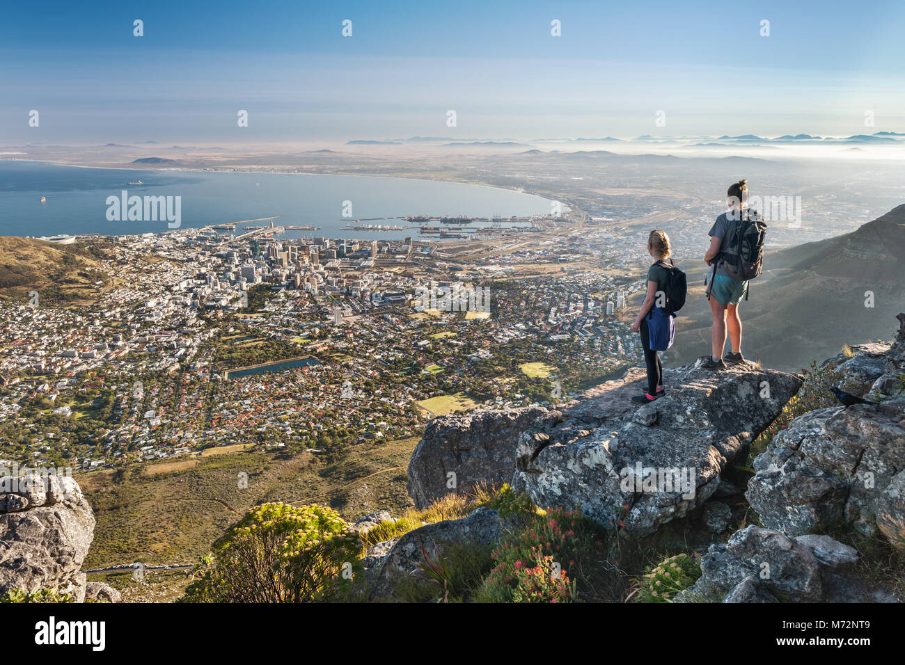 Two hikers admiring the view of Cape Town from a viewpoint along the India Venster hiking path on Table Mountain. Stock Photo