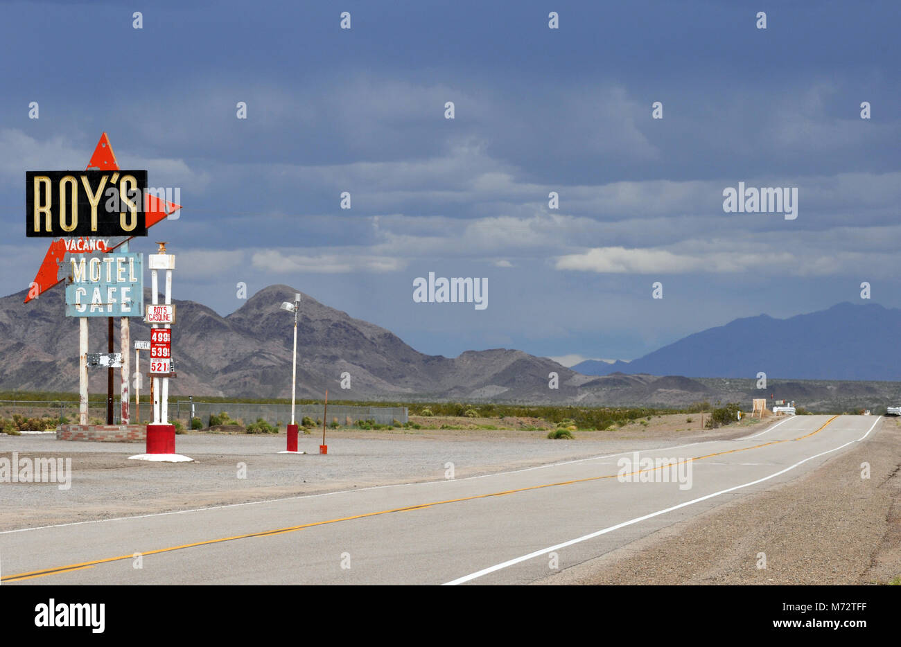 The iconic Roy's Motel and Cafe sign stands under threatening skies along a deserted stretch of Route 66 in Amboy, California. Stock Photo