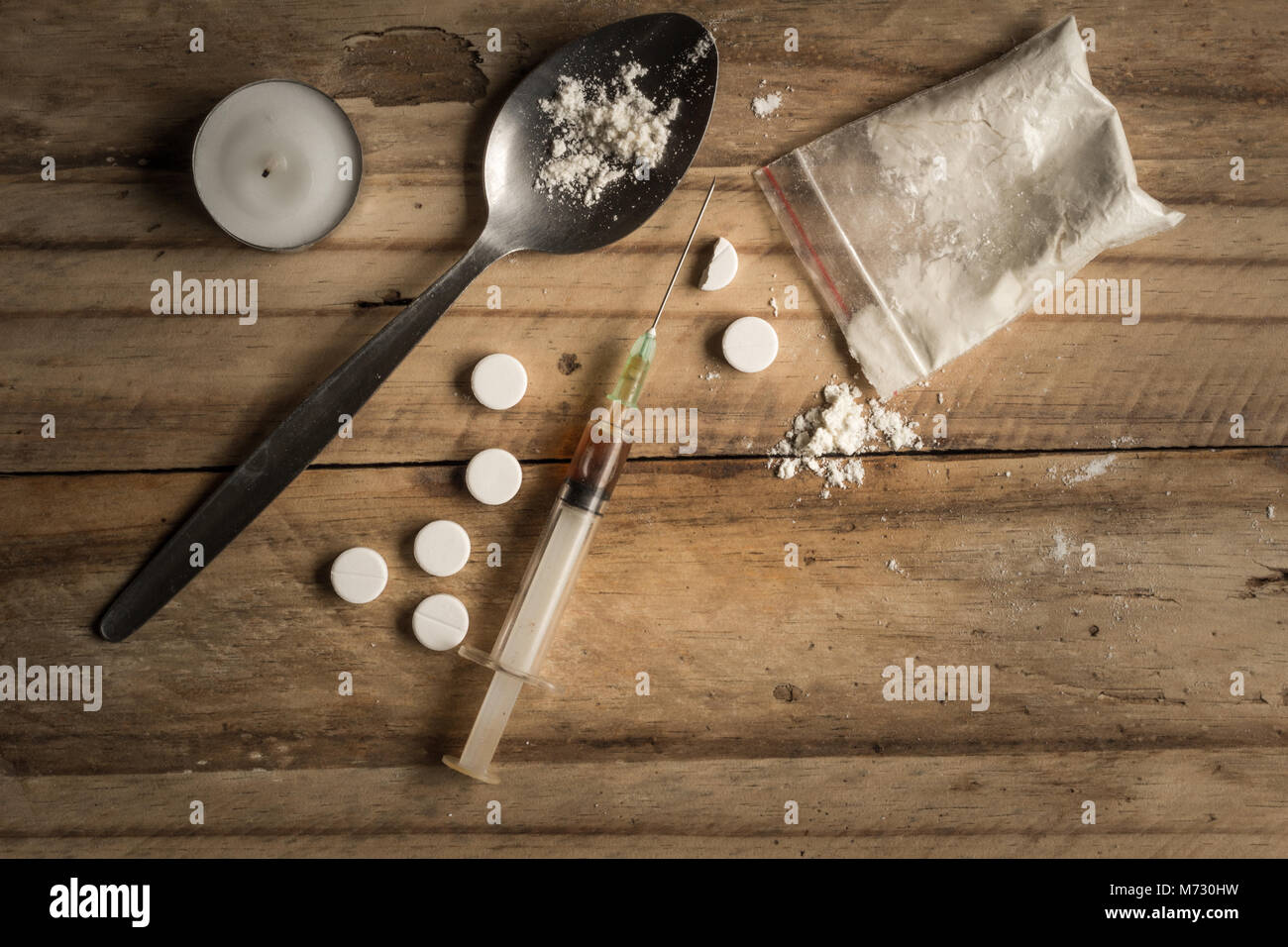 Drugs, powder, spoon, and tablets on rustic wooden background. Drug addiction concept background with space for text Stock Photo