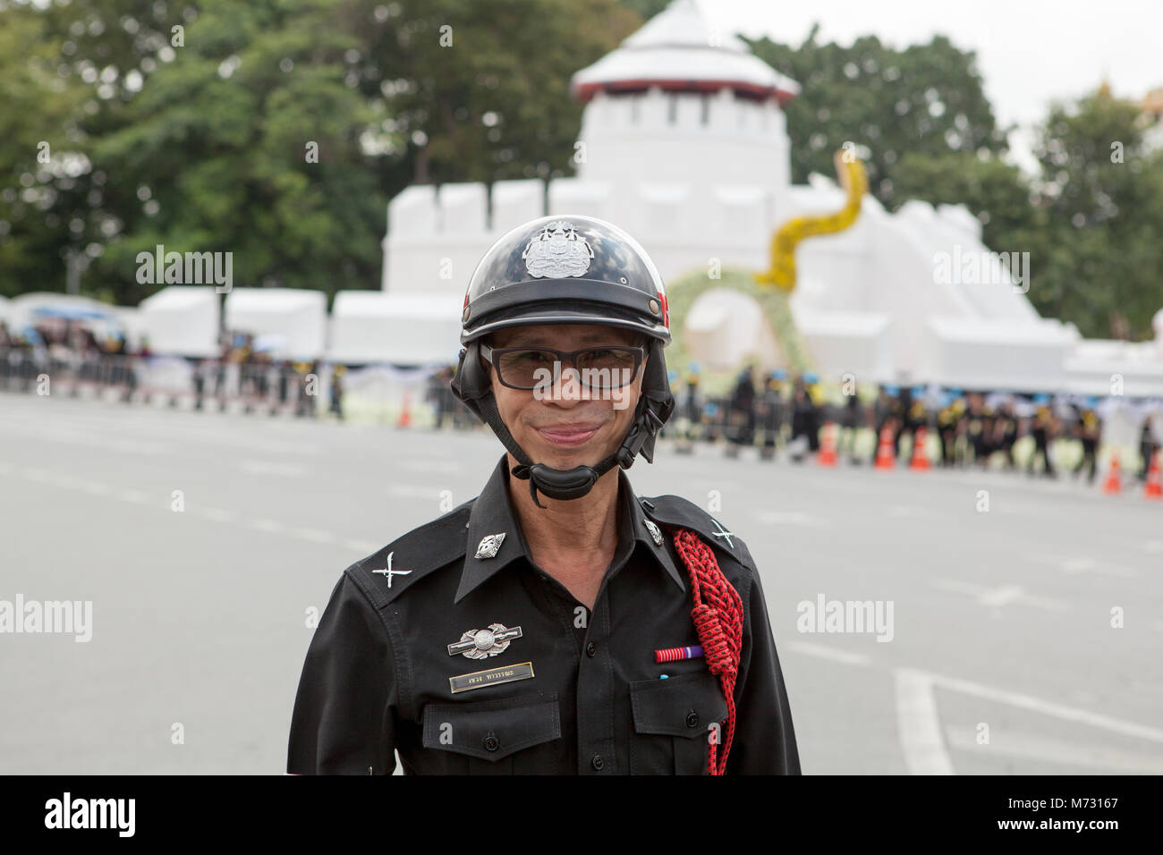 Portrait of a smiling Thai police officer, in Ratchadamnoen Road in Bangkok the day of the Royal Cremation of the Thai king Stock Photo