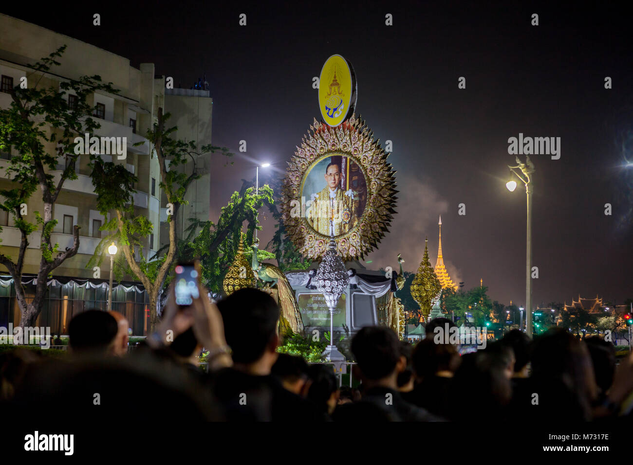 Ashes of king Bhumibol Adulyadej coming out of the stupa at Sanam Luang. View among people at Ratchadamnoen Road, with image of the king in the street Stock Photo
