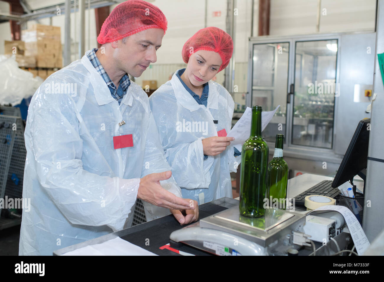 Quality Control Operative Quality control operative weighing empty bottle Stock Photo - Alamy