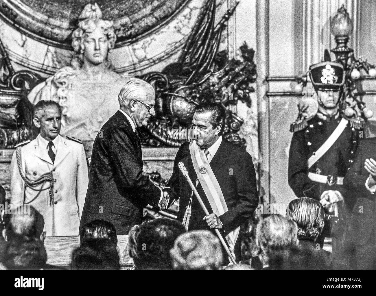 Buenos Aires, Argentina, 10 Dec 1983. File photo of the inauguration ceremony of Argentine President  Raul Alfonsin marking the return of democracy to Argentina after years of military dictatorships. The last de-facto president,  General Reynaldo Bignone (L), shakes hands with Alfonsin after giving him the presidential sash and baton at Buenos Aires government house.  Bignone died on March 7, 2018.  Photo by Enrique Shore Stock Photo
