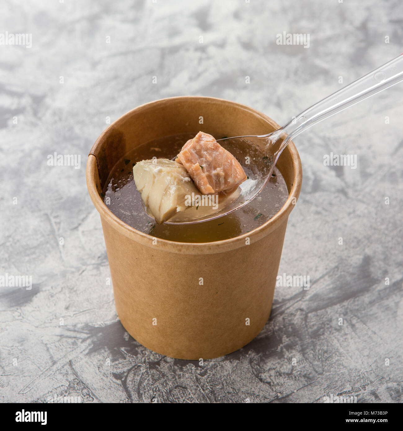 Fish Salmon soup in paper cup. Healthy food delivery. Fitness food. Weight loss nutrition diet