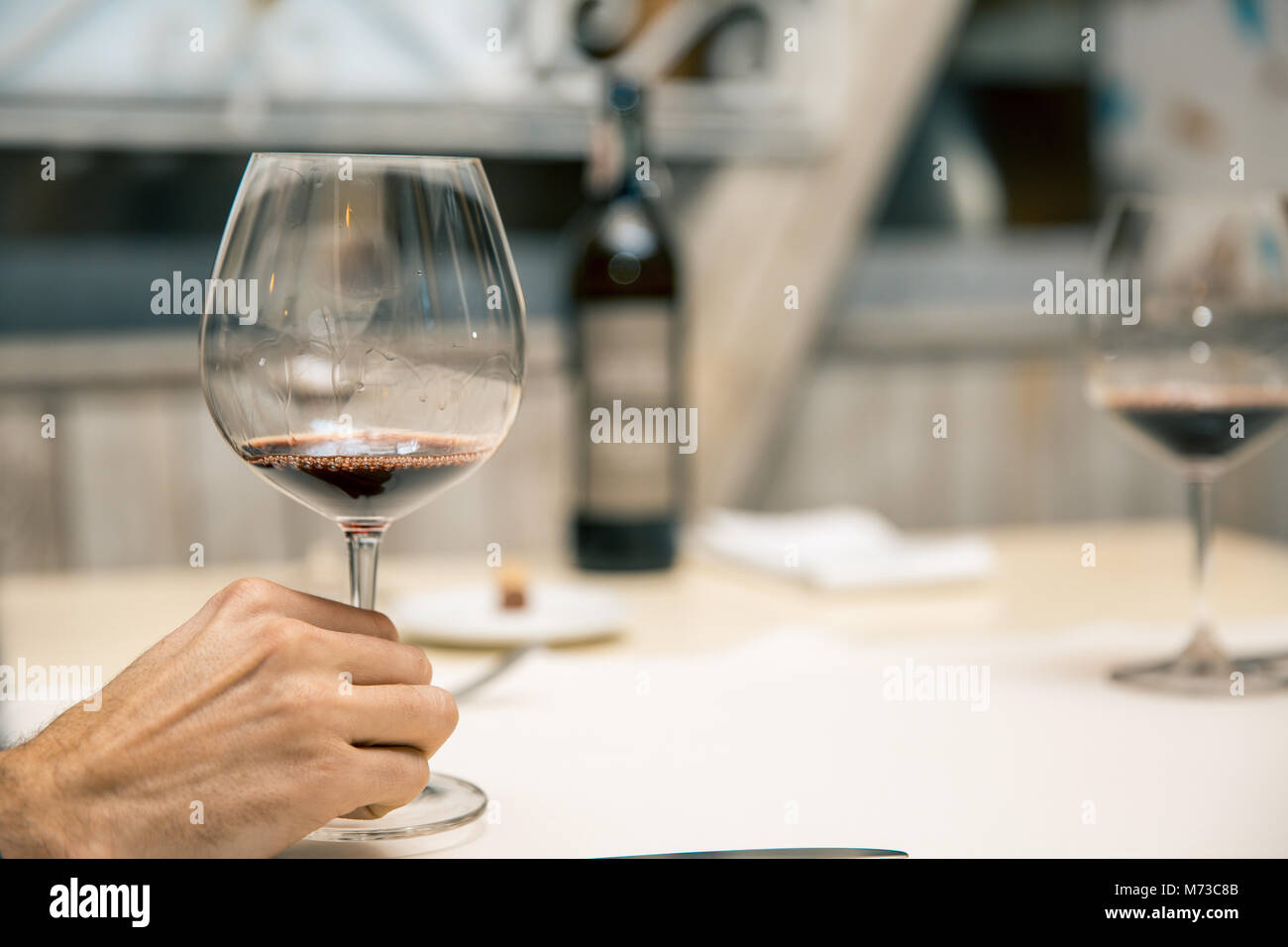 Man holding glass of wine in restaurant. wine tasting Stock Photo - Alamy