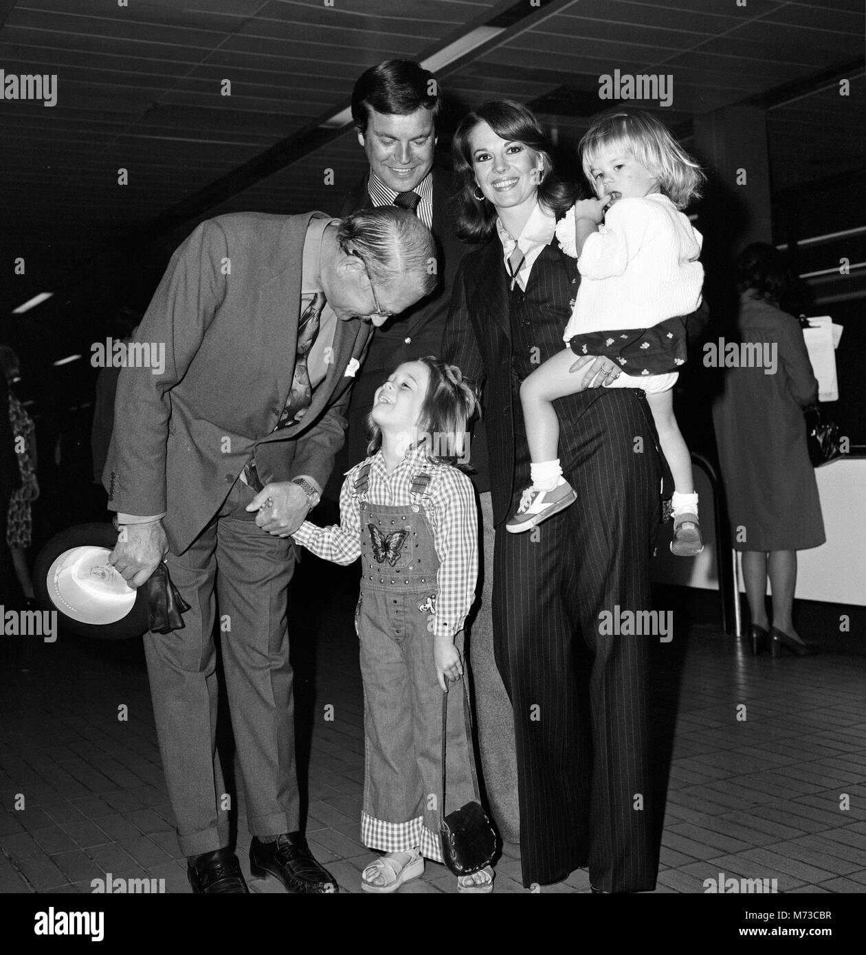 Film actor Robert Wagner and his wife Natalie Wood arrived at Heathrow Airport from Los Angeles with their children Courtney (2) and Natasha (5). Courtney was carrying a doll called 'Curious George.' They were met by Lord Olivier and are here to make a Granada TV production with him of 'Cat on a Hot Tin Roof .' 19th May 1976. Stock Photo