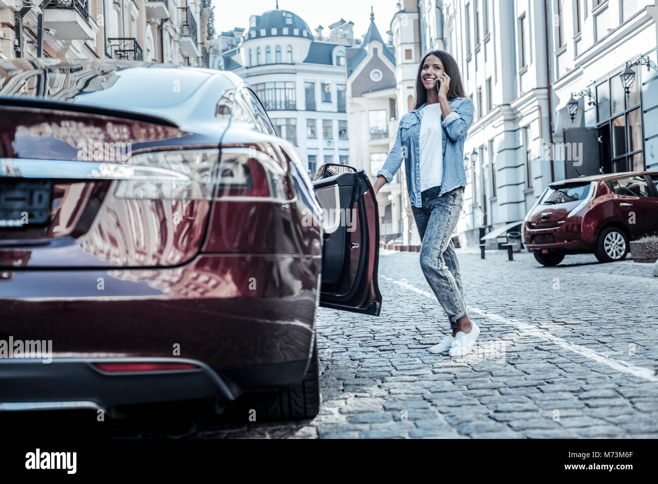 Happy young woman opening her car door Stock Photo - Alamy