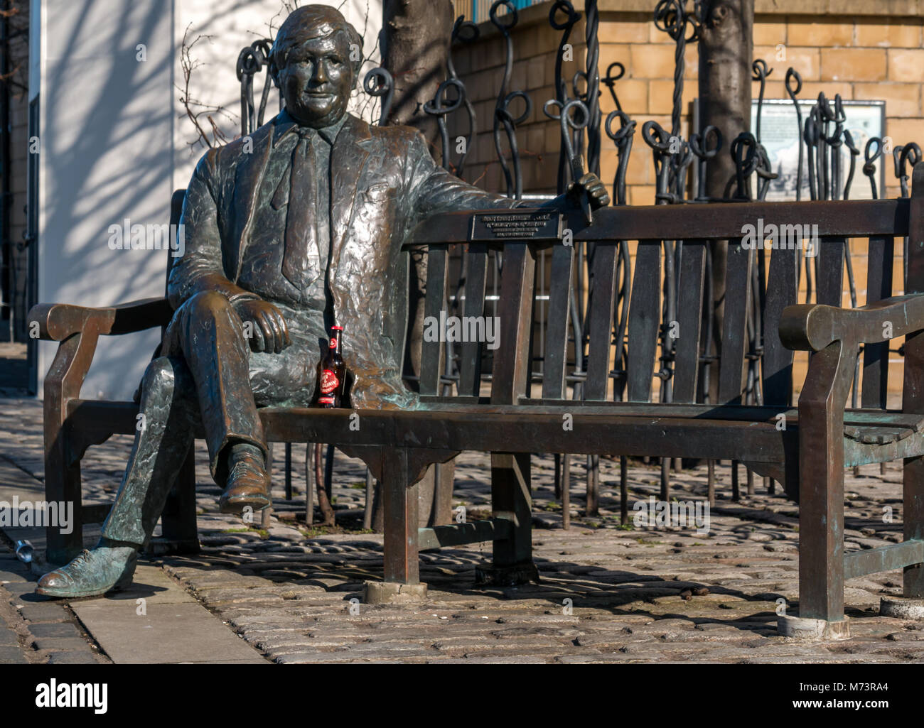 The Shore, Leith Harbour, Leith, Edinburgh, Scotland, United Kingdom, 8th March 2018. UK Weather: Spring weather along the Water of Leith. The life size bronze sculpture of businessman Sandy Irvine Robertson, by sculptor Lucy Poett, with a bottle of Innis & Gunn beer Stock Photo