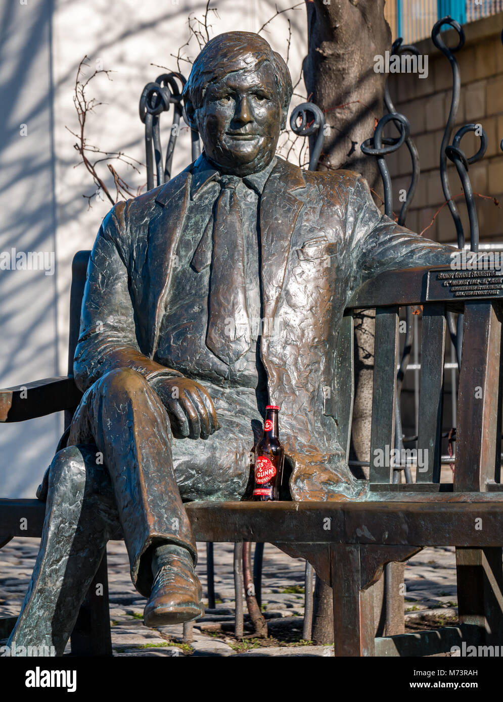 The Shore, Leith Harbour, Leith, Edinburgh, Scotland, United Kingdom, 8th March 2018. UK Weather: Spring weather along the Water of Leith. The life size bronze sculpture of businessman Sandy Irvine Robertson, by sculptor Lucy Poett, with a bottle of Innis & Gunn beer Stock Photo