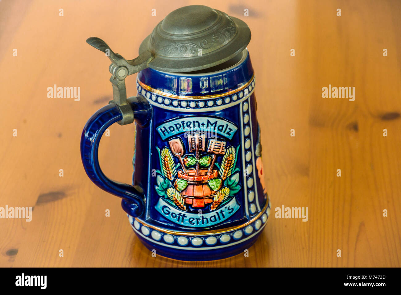 A German porcelain beer stein with a hinged pewter lid and there is a toast on it. Stock Photo