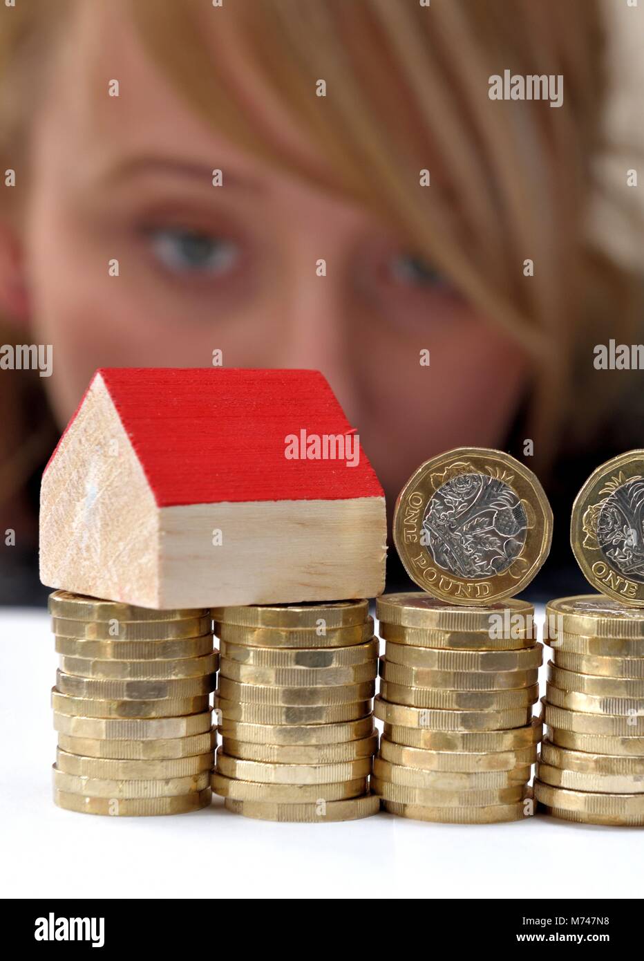 A small house on a stack of one pound coins house buying concept Stock Photo