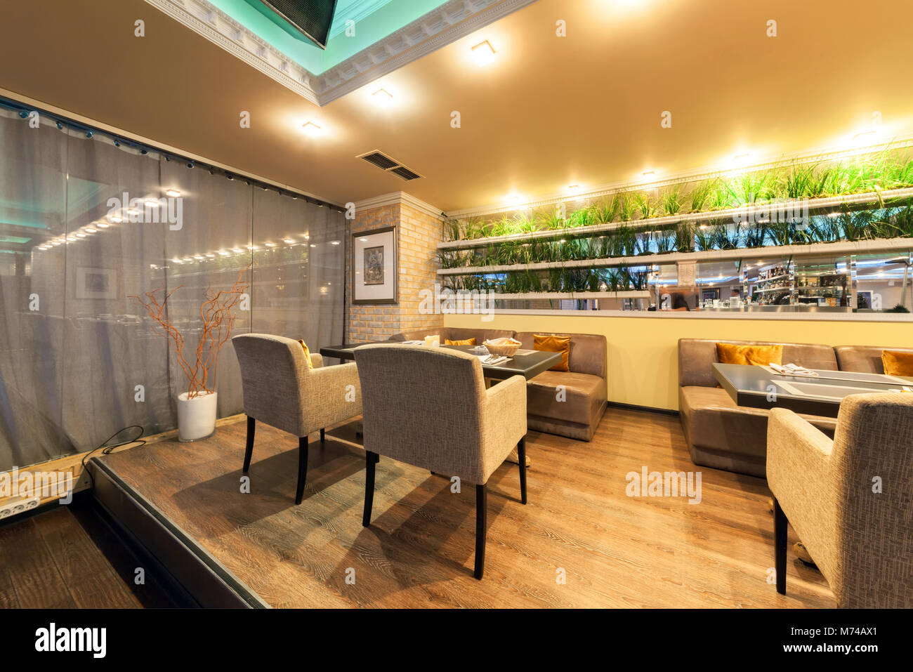 MOSCOW - JULY 2014: Interior of stylish Mediterranean cuisine Italian restaurant - 'SILLYCAT'. Restaurant room with a leather sofa, table and chairs Stock Photo