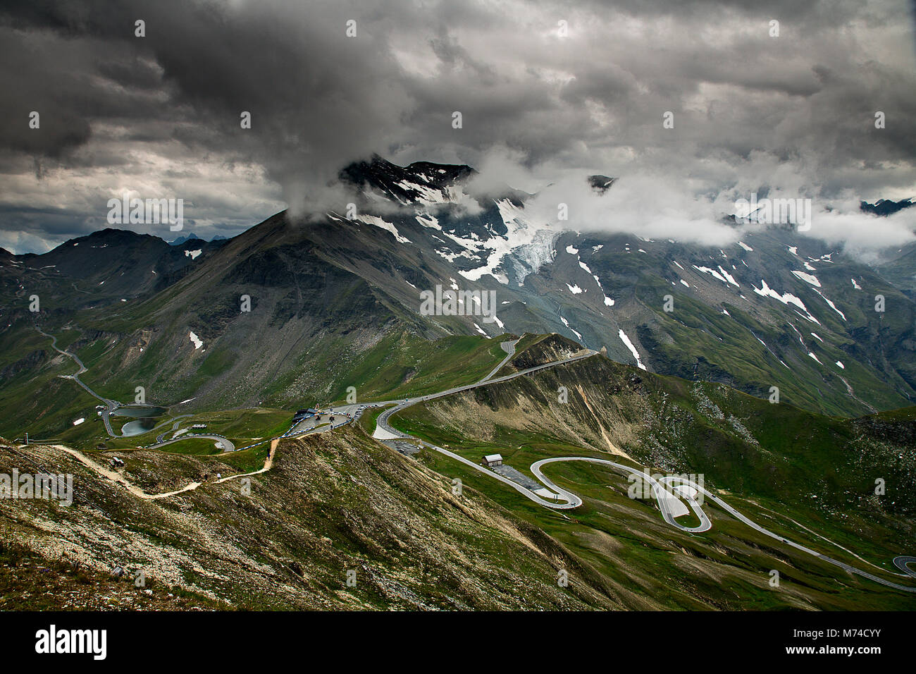 Winding road high in the Austrian Alps under stormy skies Stock Photo
