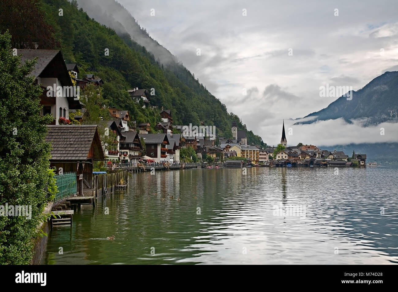 The town of Hallstatt, Austria, with reflections in lake on a misty day Stock Photo