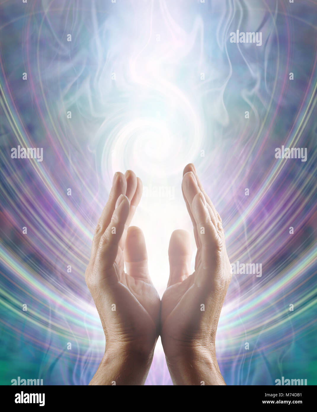 Sensing Spiralling Healing Energy - male  hands reaching up and sensing an ethereal spiralling white light flowing energy form with copy space Stock Photo