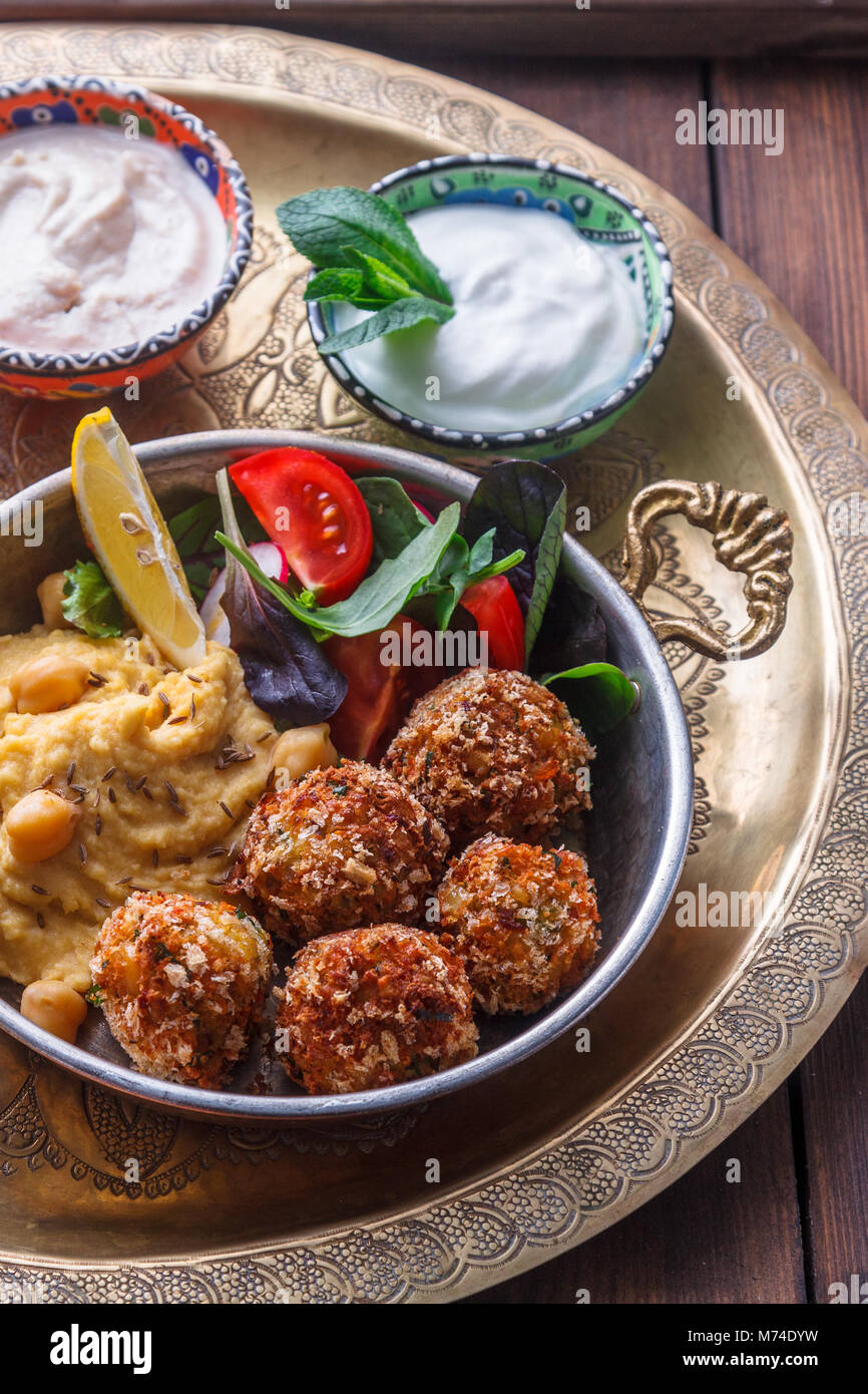 Hummus, falafel, salad in a pan with yoghurt and tahini Stock Photo