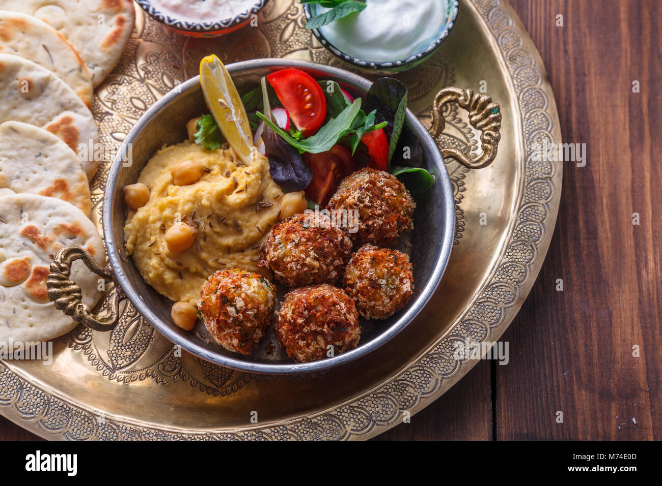 Hummus, falafel, salad in a pan with yoghurt and tahini Stock Photo