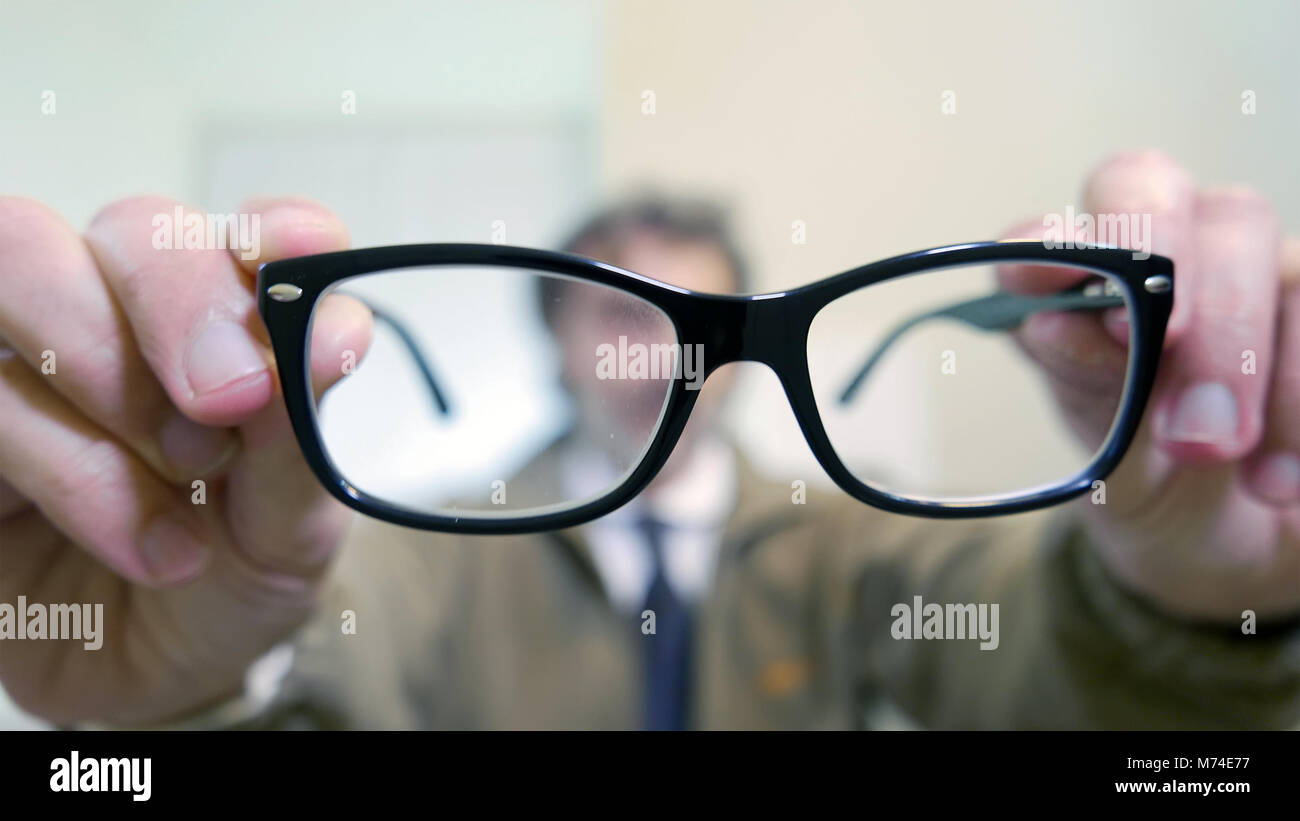 presbyopia concept, man holding glasses Stock Photo