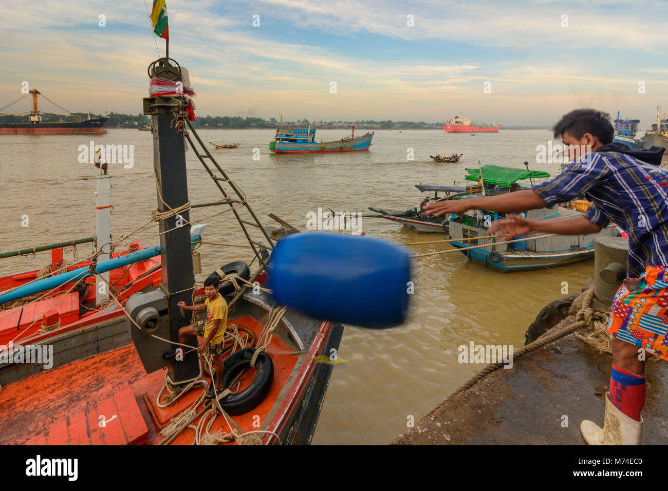 Yangon (Rangoon) San Pya Fish Market man throwing empty barrel to