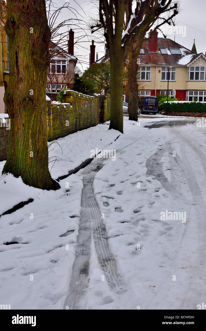 Light snow covering city residential street with car tracks, Bristol, UK Stock Photo