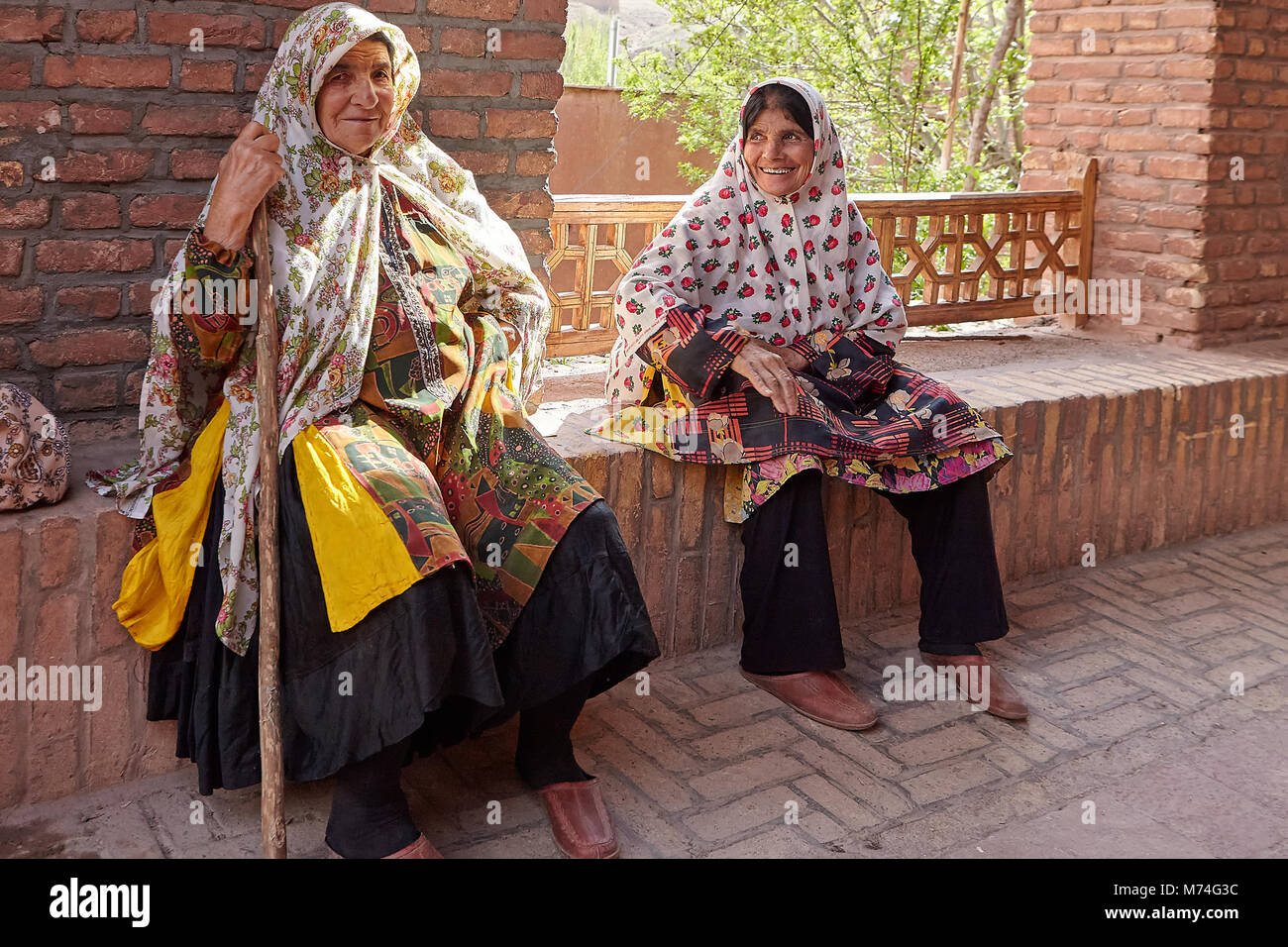 Abyaneh, Iran - April 26, 2017: two elderly Iranian women are sitting and smiling in a traditional village in the mountains. Stock Photo