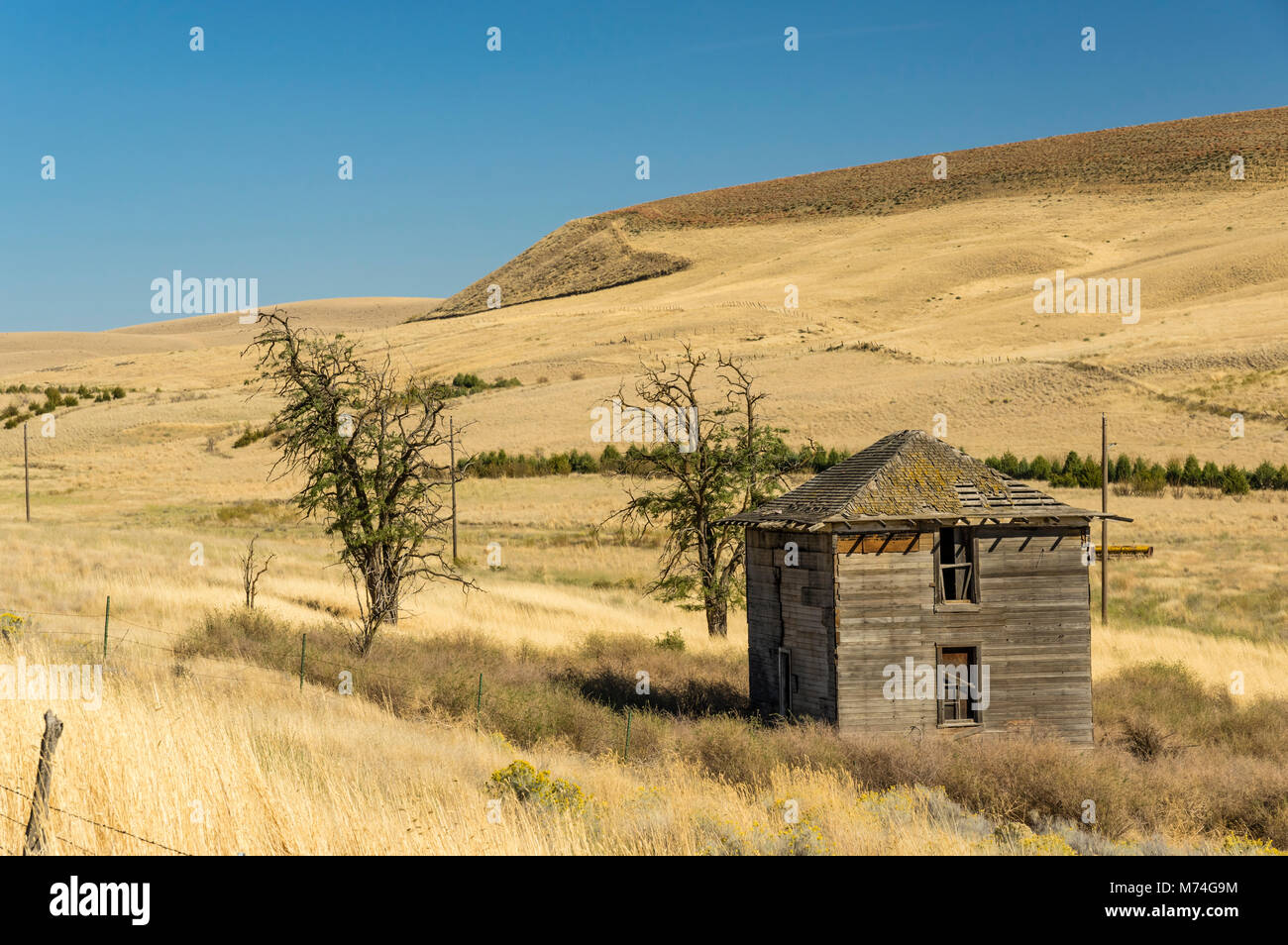 Abandoned building on a ranch in eastern Washington with dry praire in the background Stock Photo
