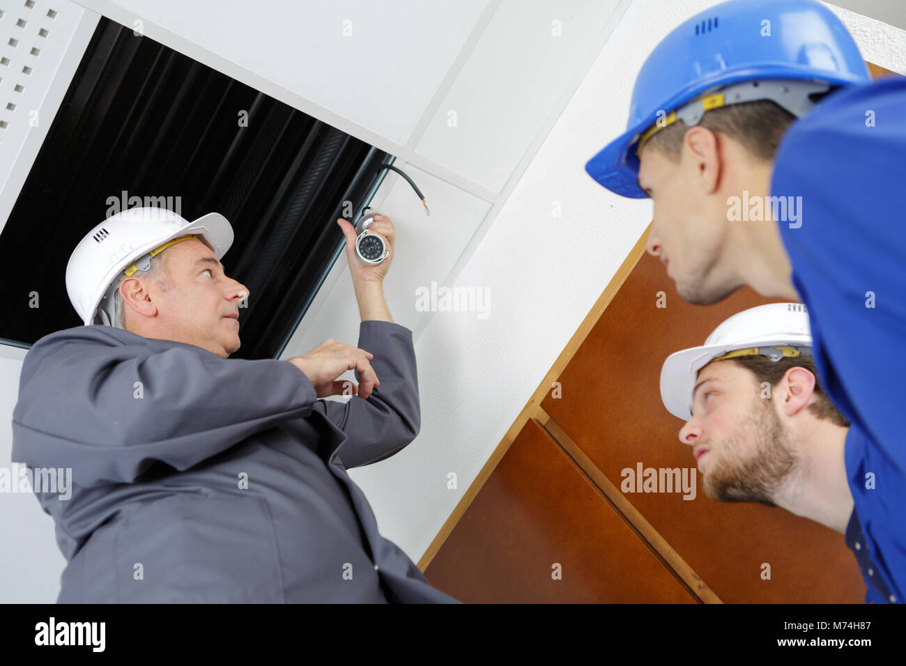 electrician demonstrating on installing hanging lights Stock Photo Alamy