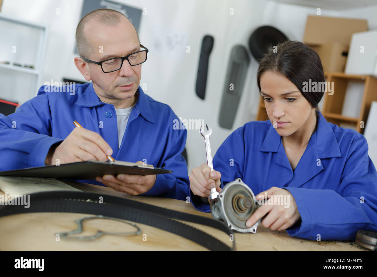 female apprentice in car service station with big wrench Stock Photo