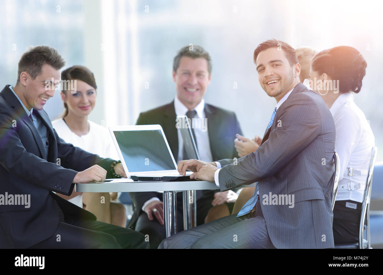 group of smiling business people sitting in a meeting room Stock Photo ...